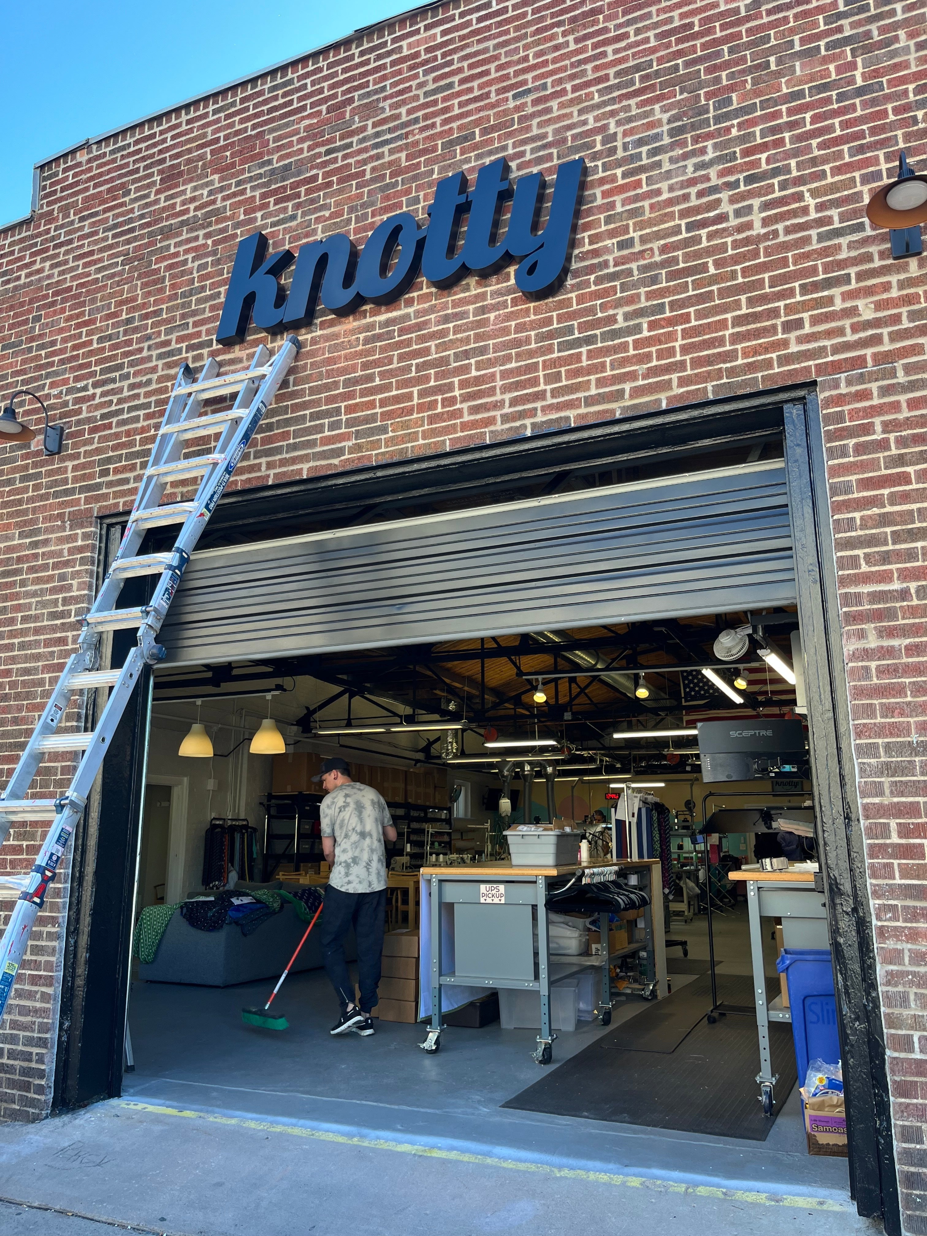 Person working inside a building with 'knotty' branding on the exterior.