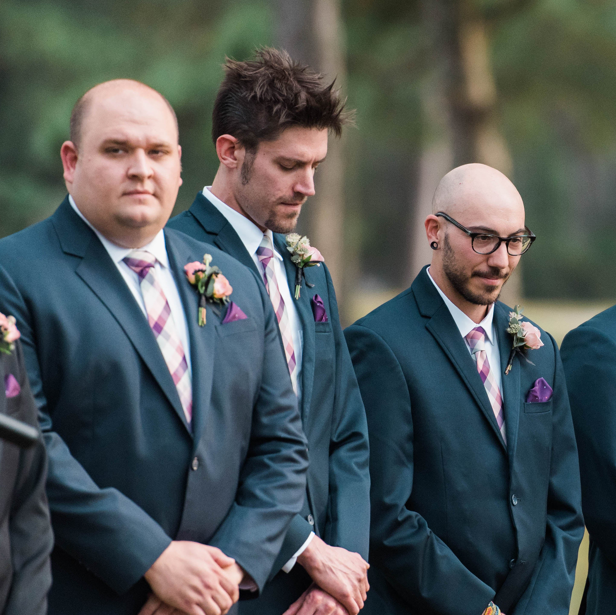 Groomsmen standing in a line during an outdoor wedding ceremony