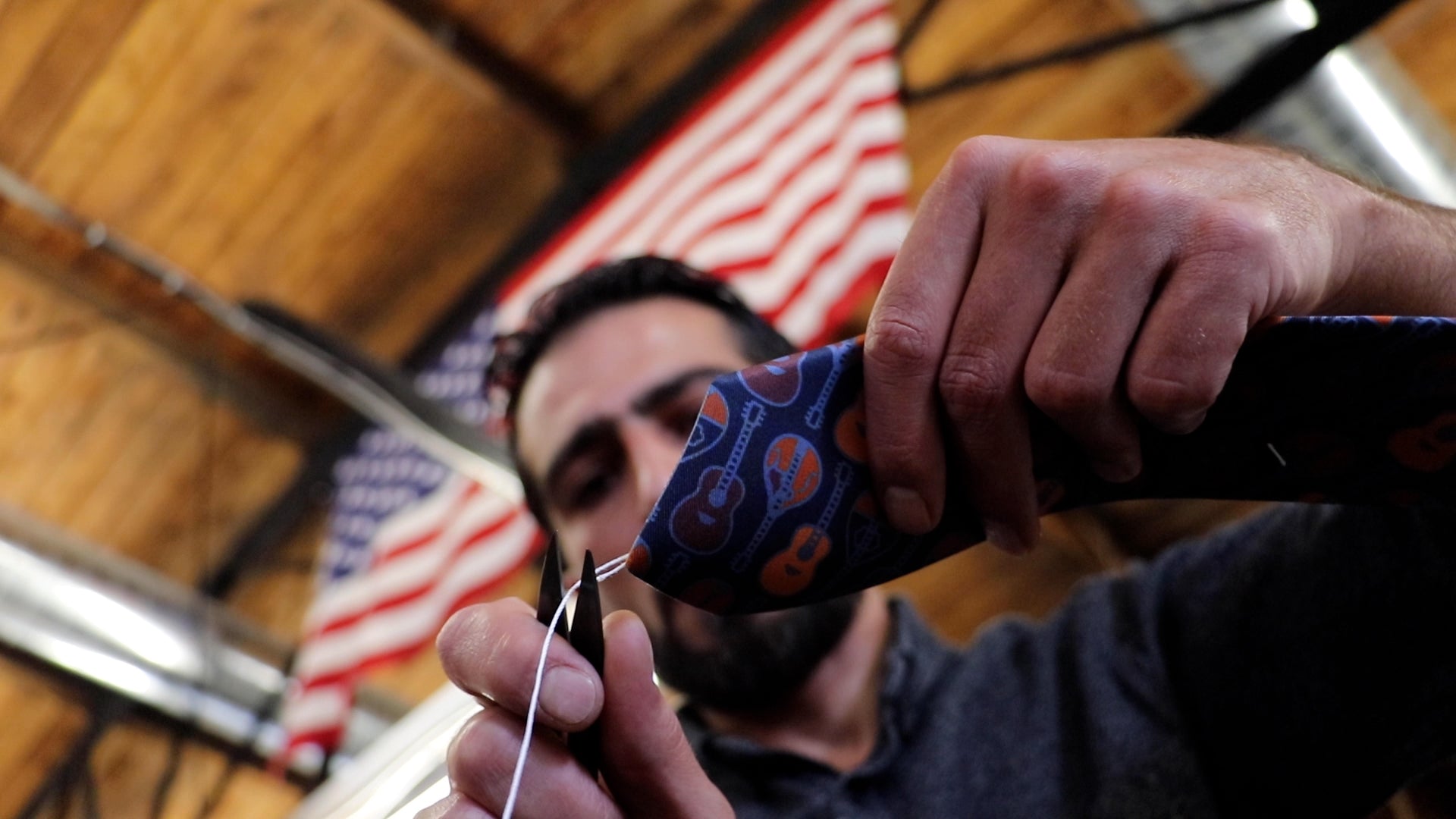 Man trimming a necktie in American manufacturing space
