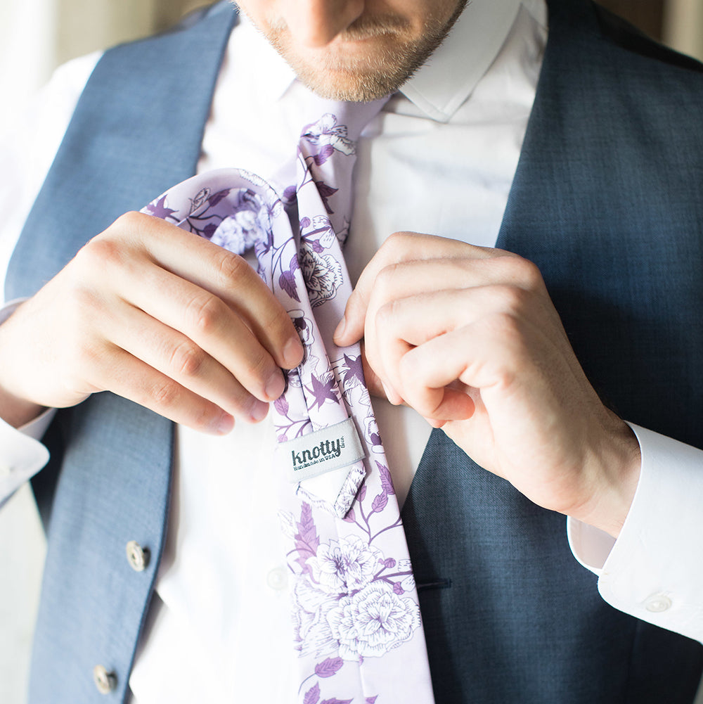 Man tucking his tie tail into the tie catch