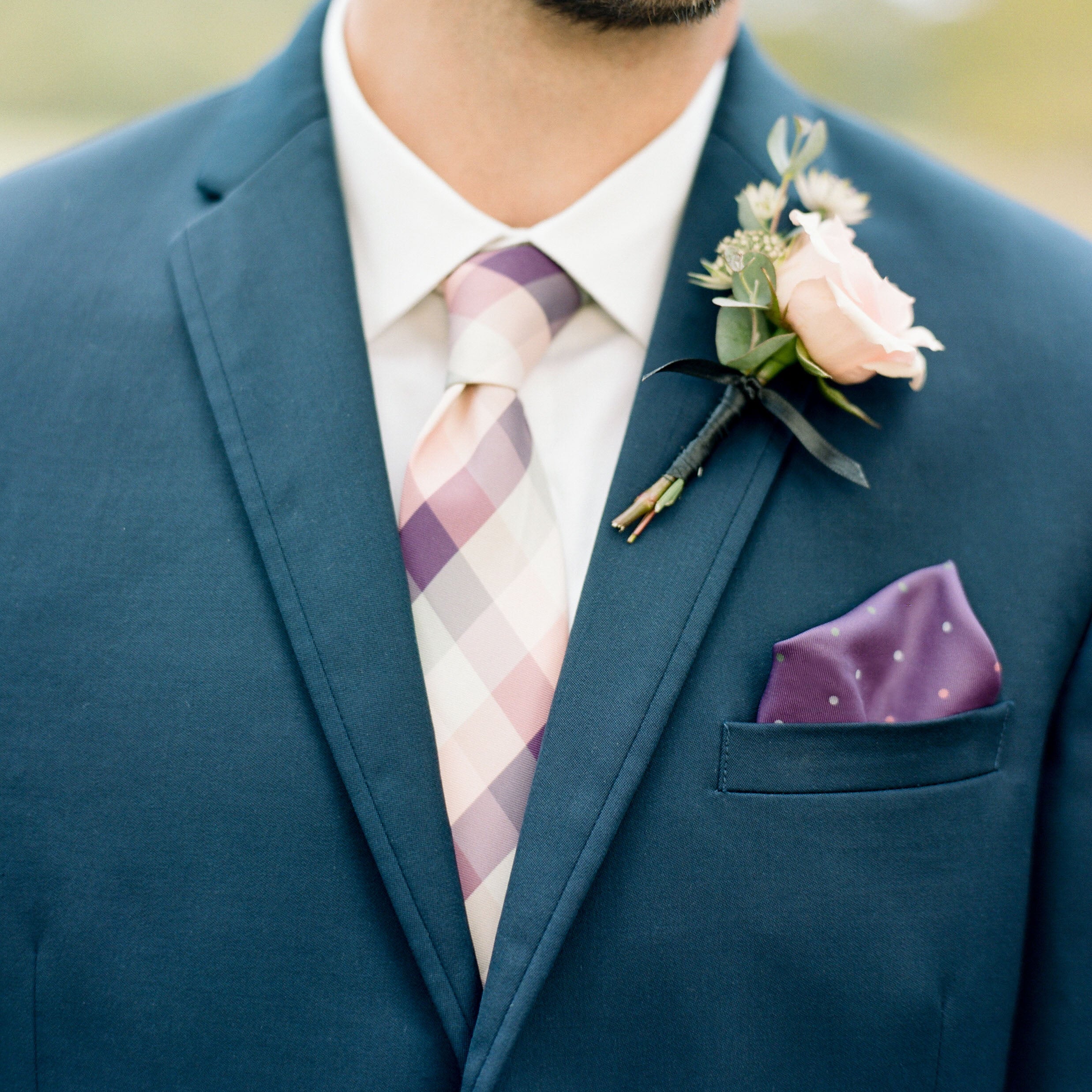 man wearing suit with plaid tie and polka dot pocket square