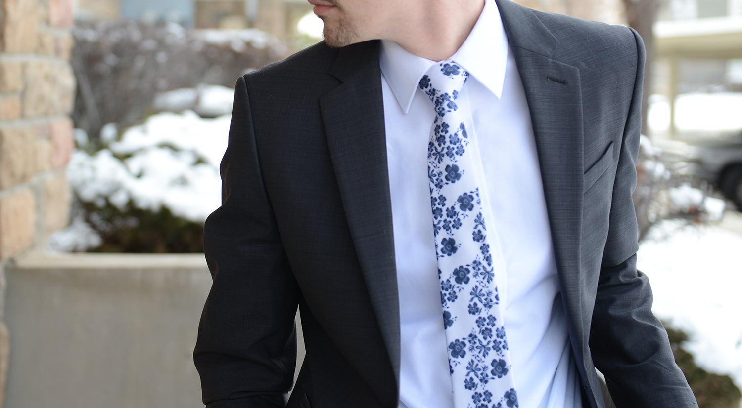 Floral necktie with dark suit outside on snowy day