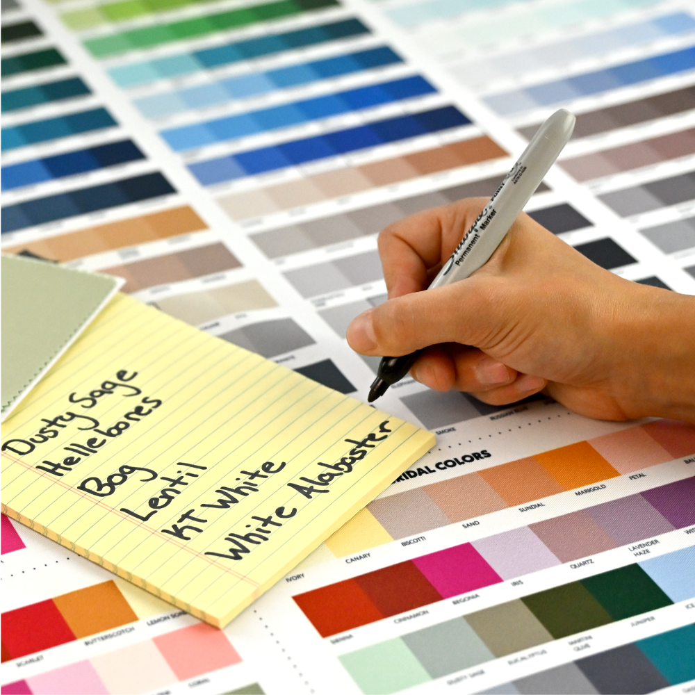 image of a hand holding a sharpie and writing down color names from the ColorMatch Chart onto a notepad