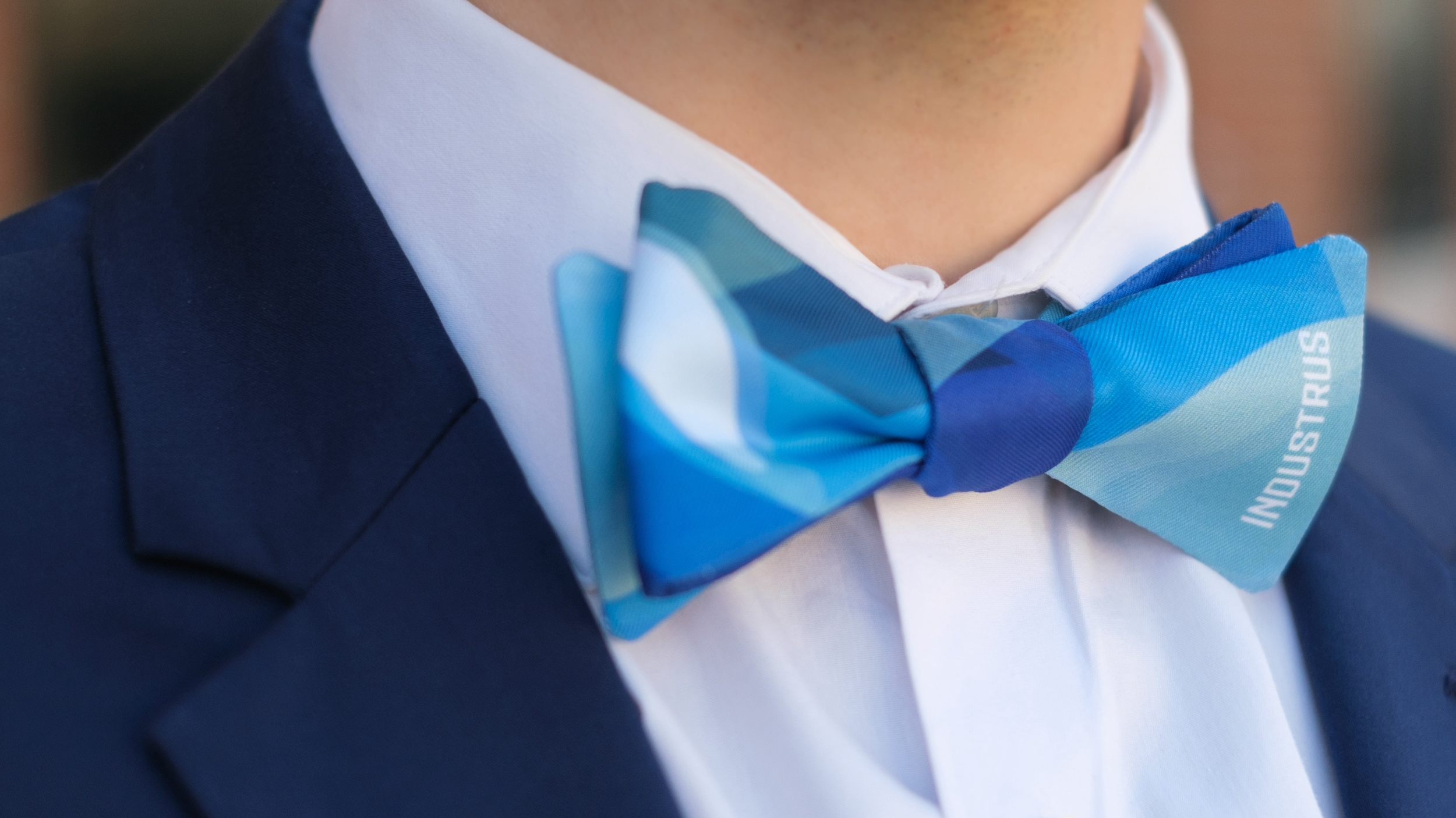 close up of a man wearing a blue custom bow tie and blue suit