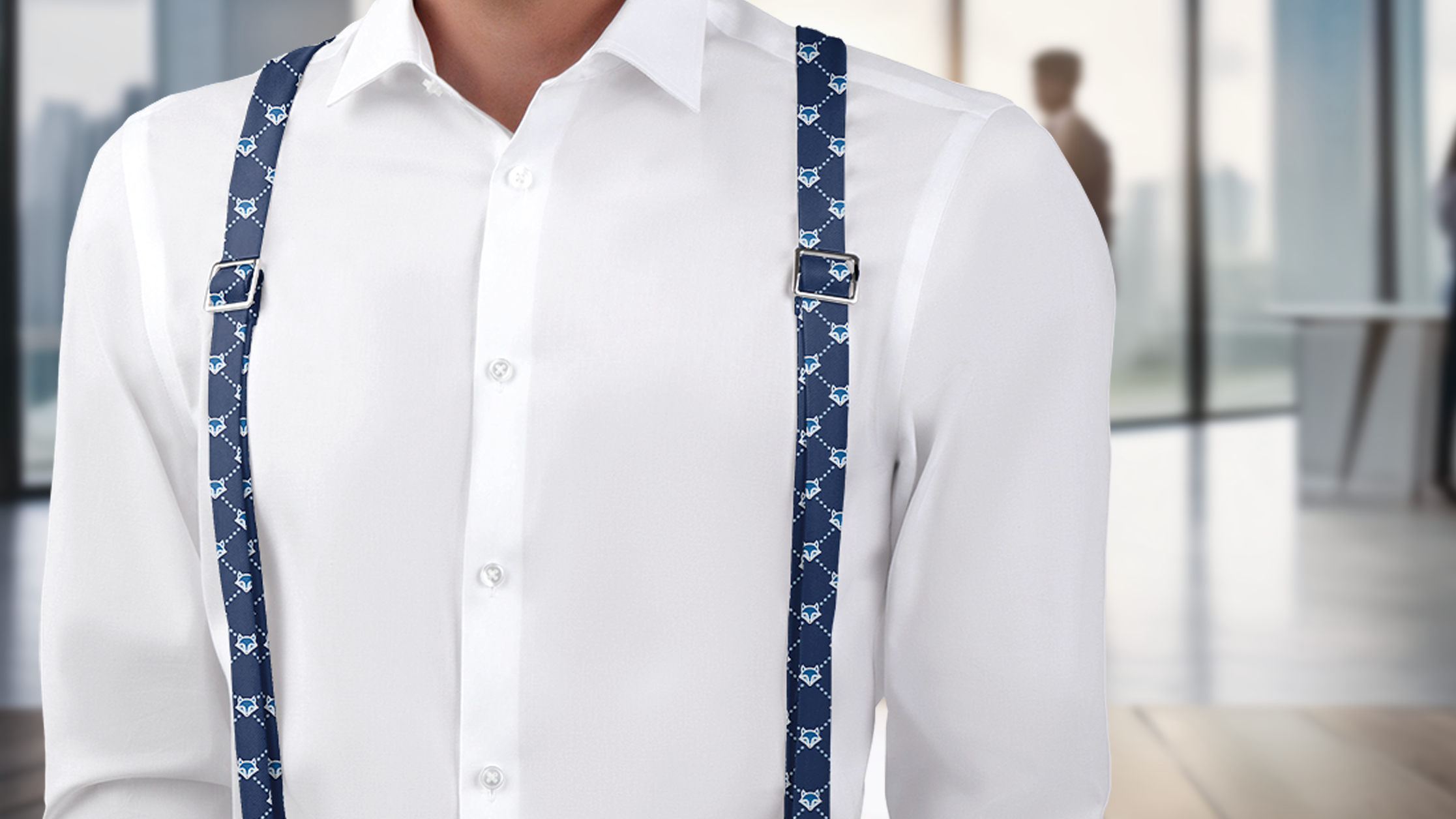 Man wearing a white shirt with blue suspenders in an office setting