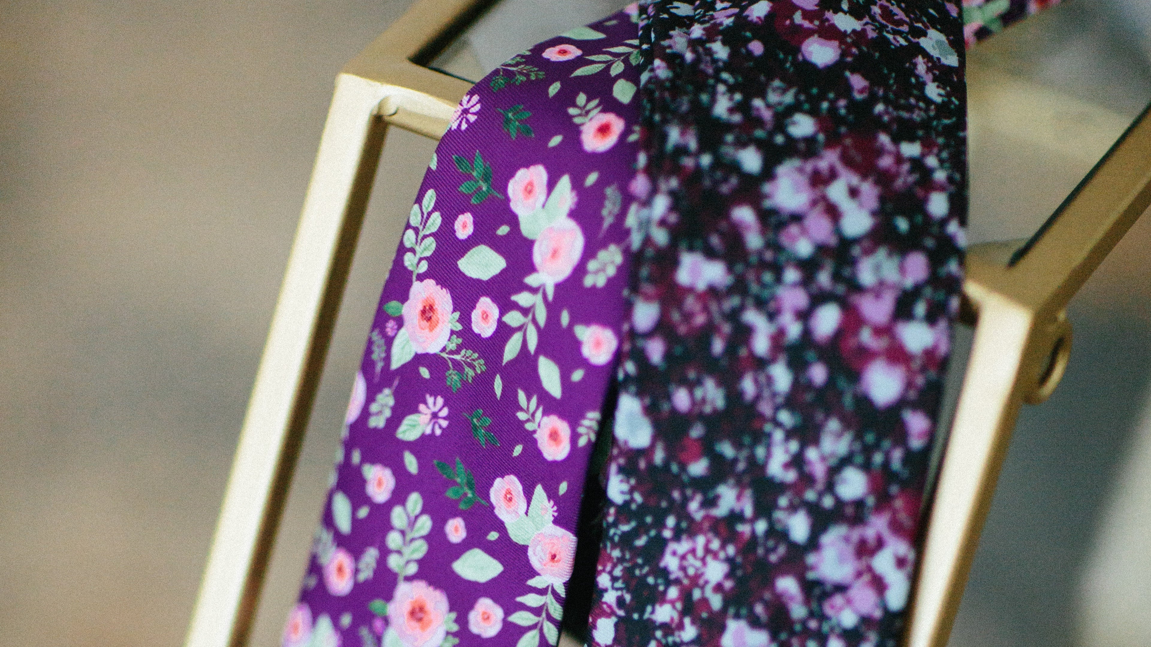 Floral neckties draped over metal vase