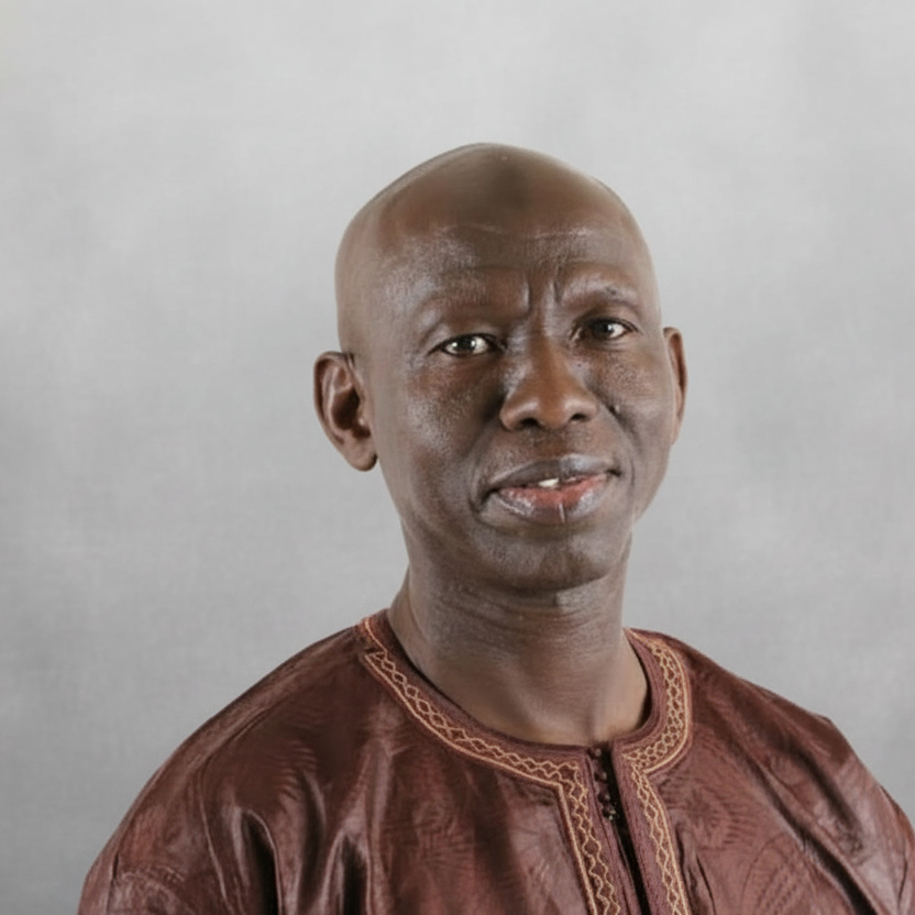 Man wearing a brown traditional outfit against a plain background