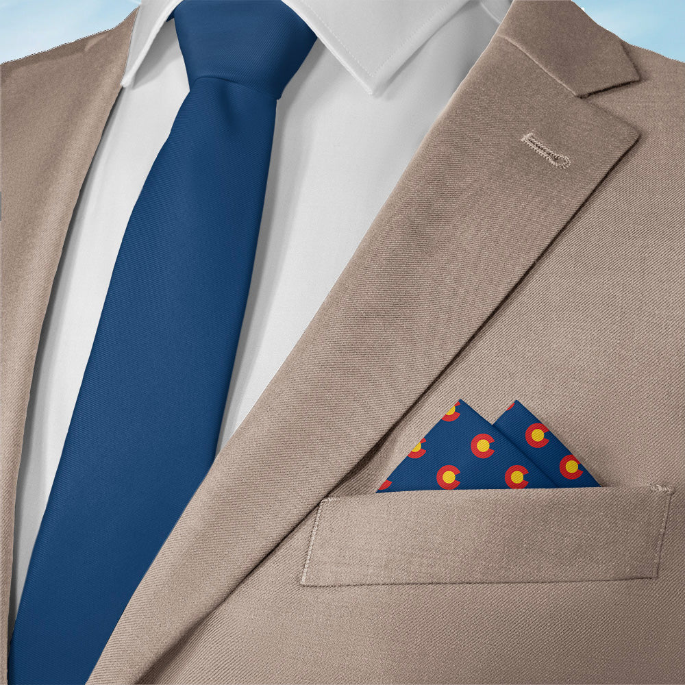 Beige suit jacket with a blue tie and Colorado-themed patterned pocket square on a white background