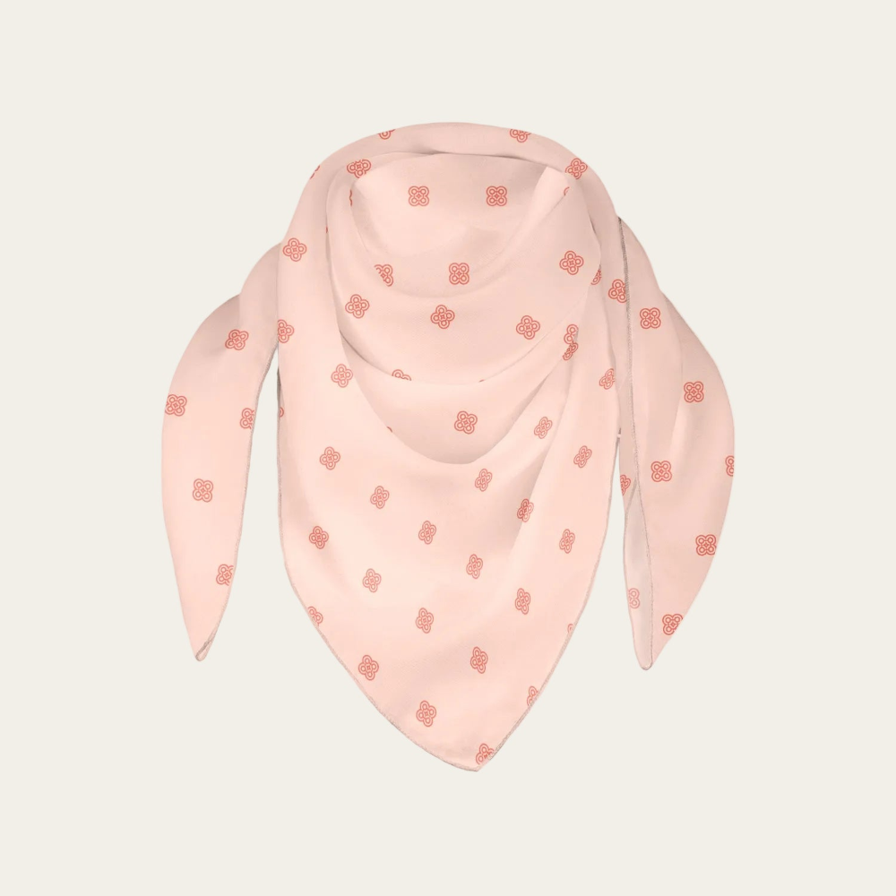 Pink scarf with subtle custom logo pattern on a light beige background