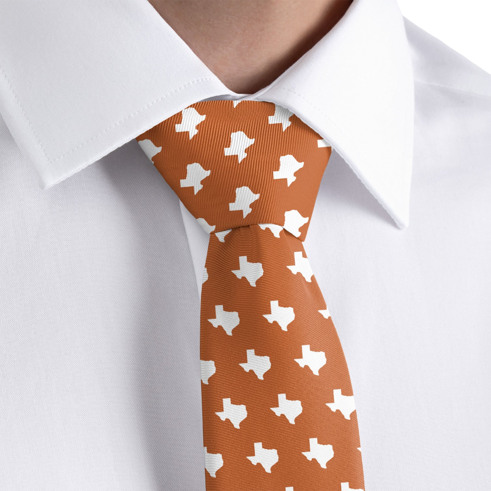 Orange tie with white Texas shape pattern worn with a white shirt