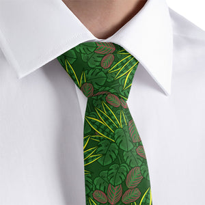 Green patterned houseplant tie worn with a white shirt on a light gray background
