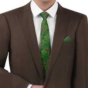 Brown suit with a green houseplant patterned tie and matching pocket square on a white background
