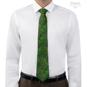Green patterned tie worn with a white shirt and brown pants on a white background