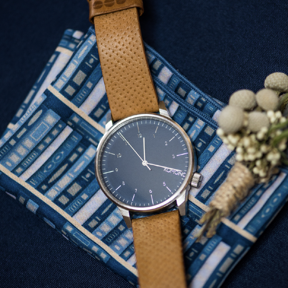 Blue book shelf design pocket square folded with watch and flowers on top