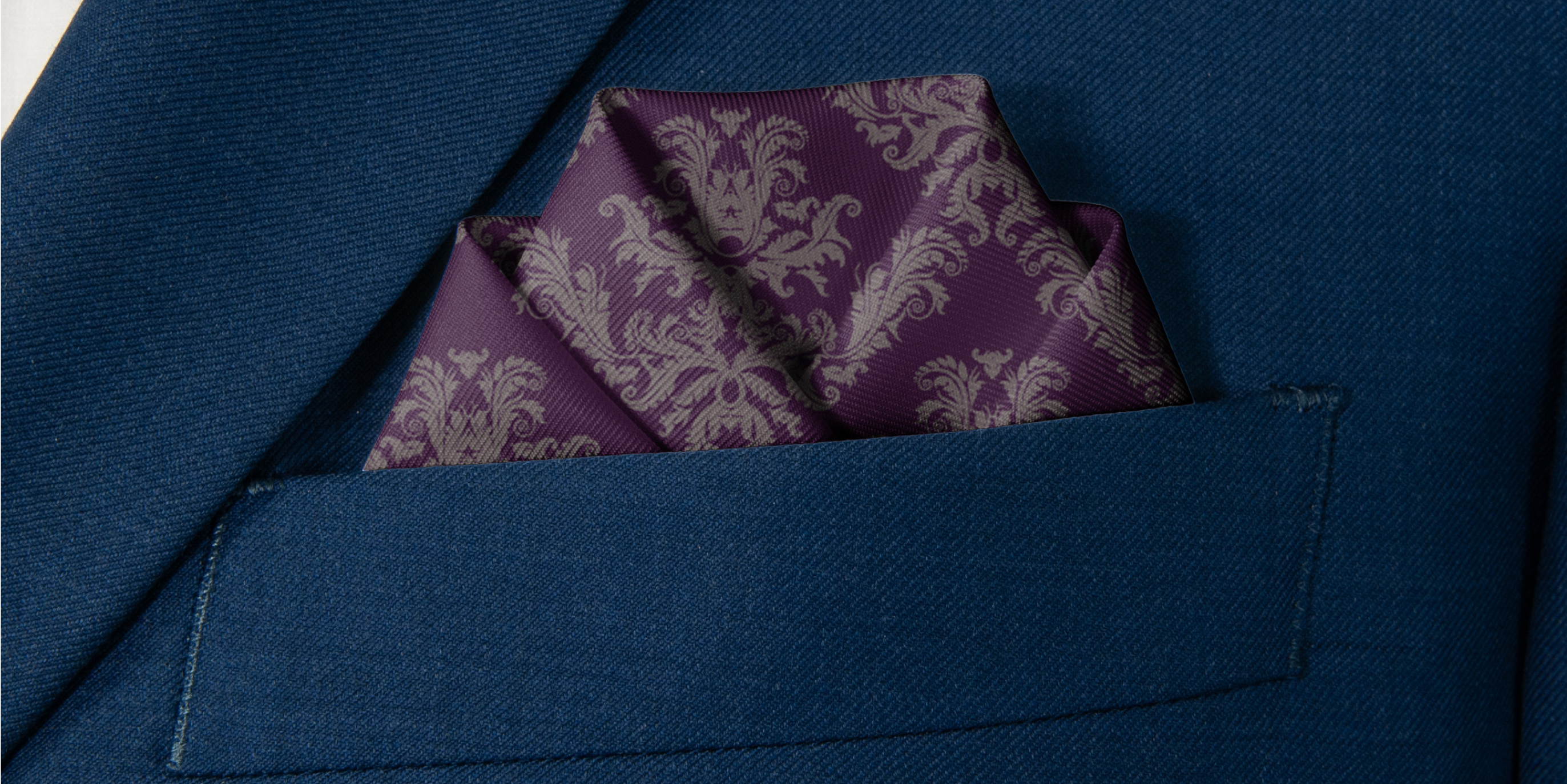 patterned pocket square folded in navy suit pocket
