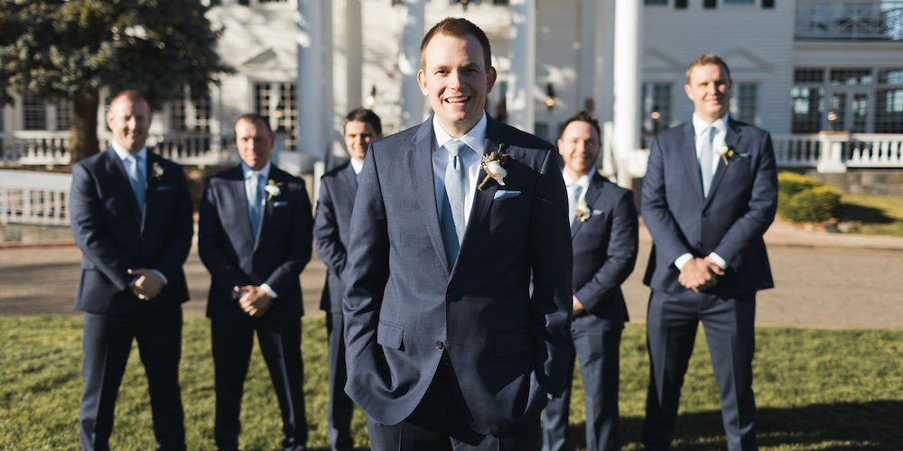 Groom standing in front of groomsmen of all heights all wearing the same suit and tie