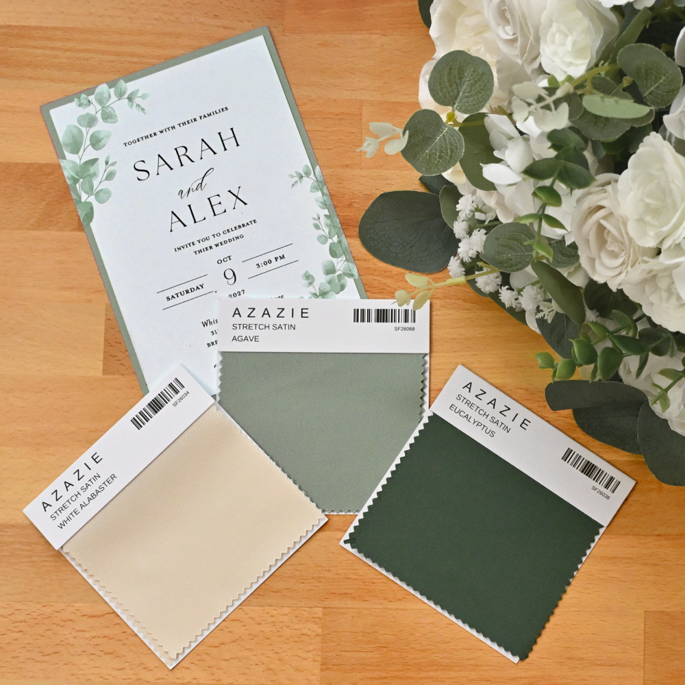 top down view of a wedding invitation, dress swatches and a bouquet of flowers on a table top