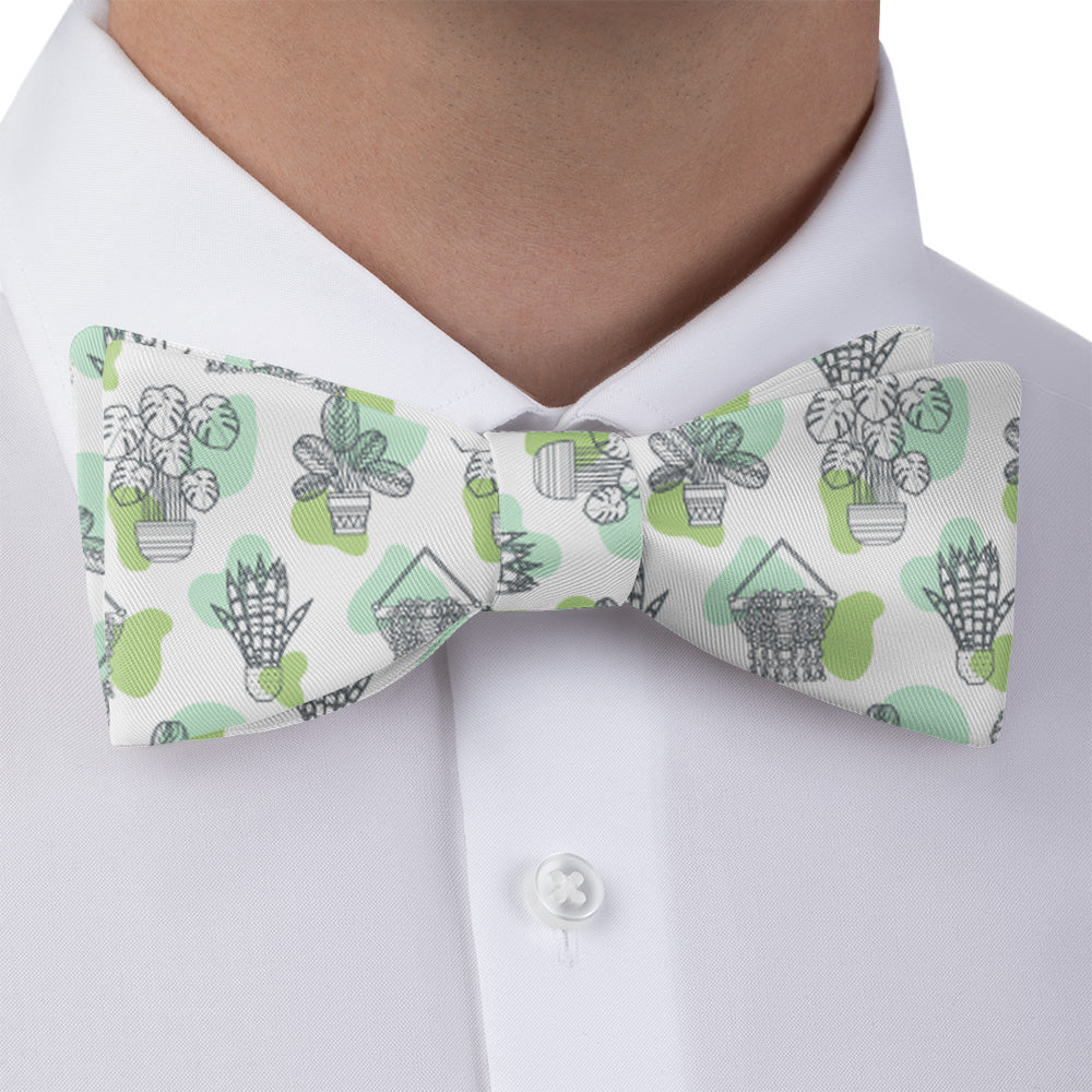 Bow tie with potted plant pattern worn by a person in a white shirt