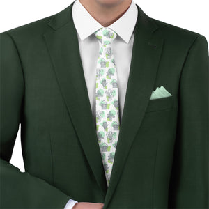 Green suit with a potted plant patterned tie and matching pocket square on a white background