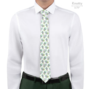 Person wearing a white shirt with a green potted plant patterned tie, standing against a white background.