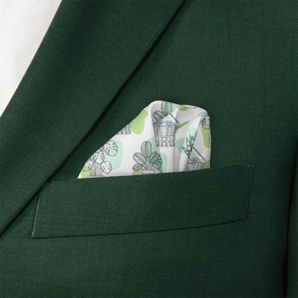 Green suit jacket with a patterned pocket square featuring potted plants.