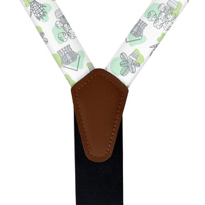 Suspenders with a potted plant patterned strap and brown vegan leather clip on a white background