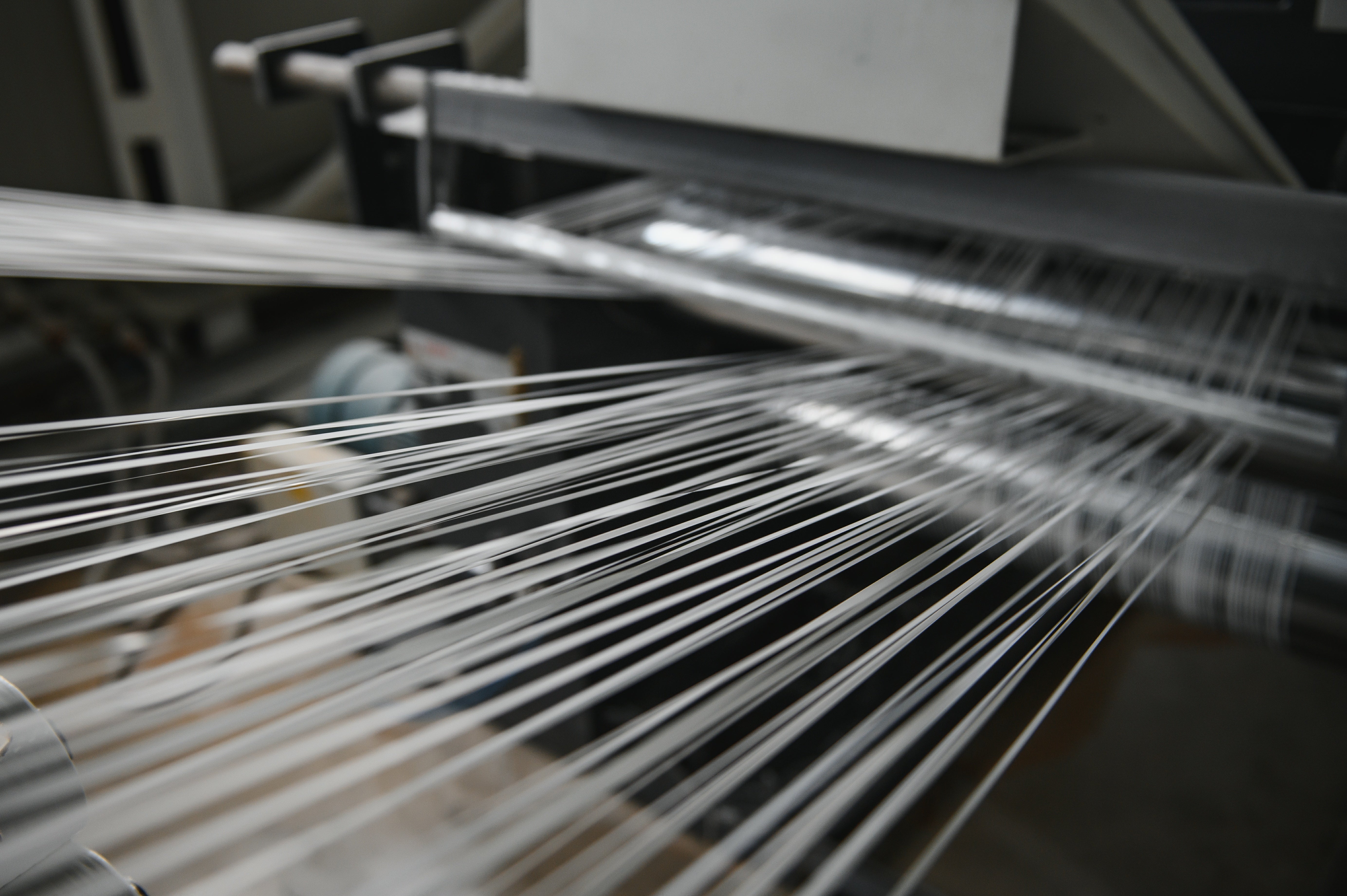 Close-up of a loom with threads in a textile factory.