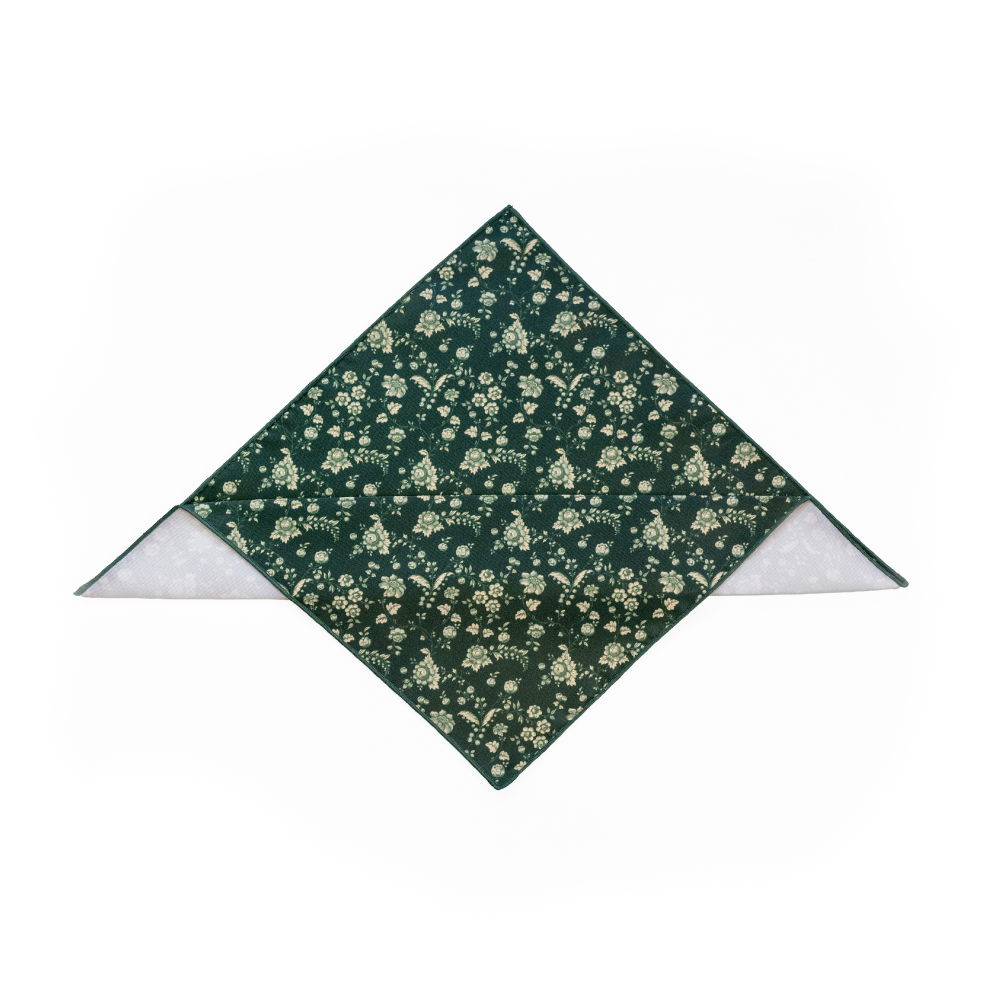 A pocket square with a dark green background and cream floral pattern, folded.