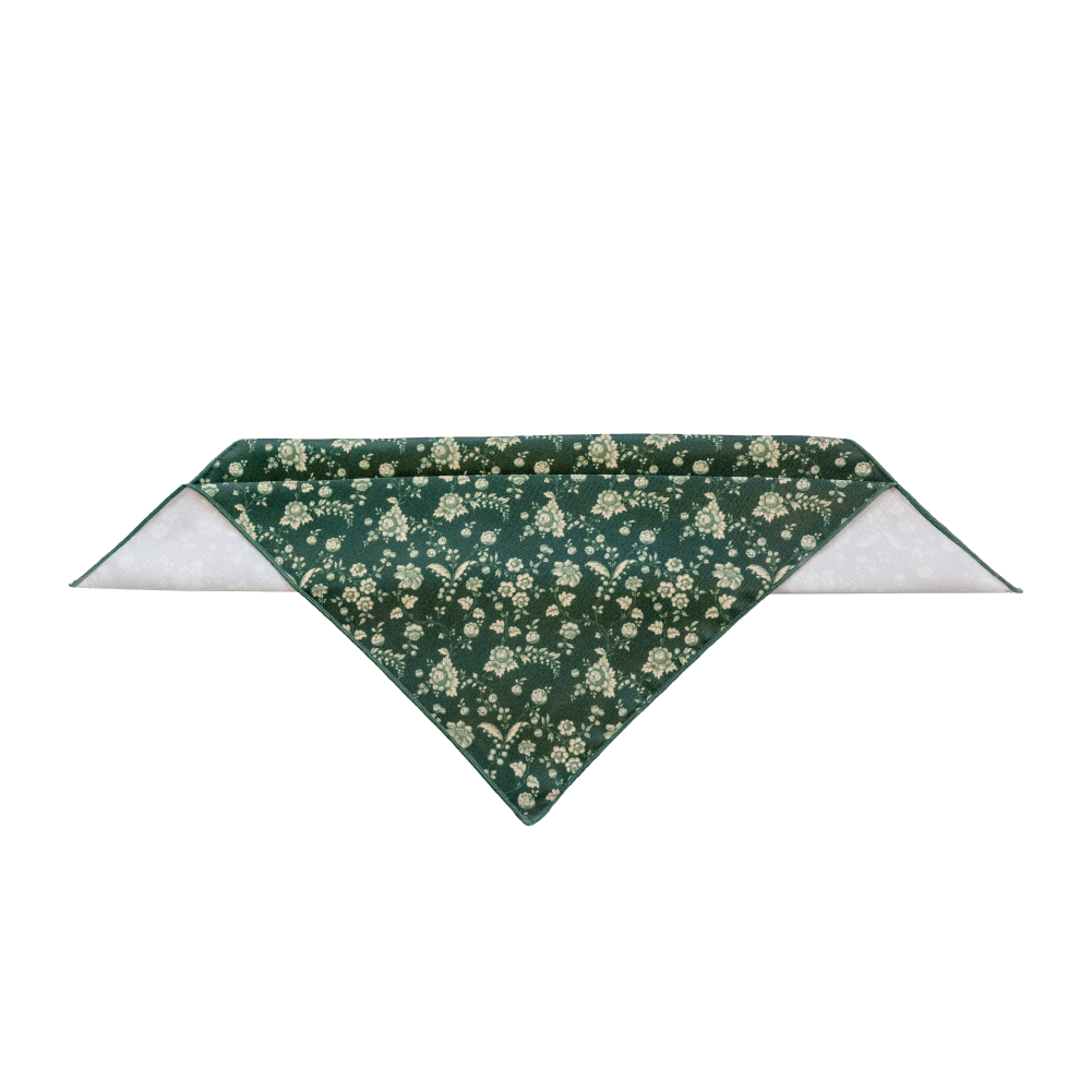 A triangular pocket square in dark green with a cream floral print.