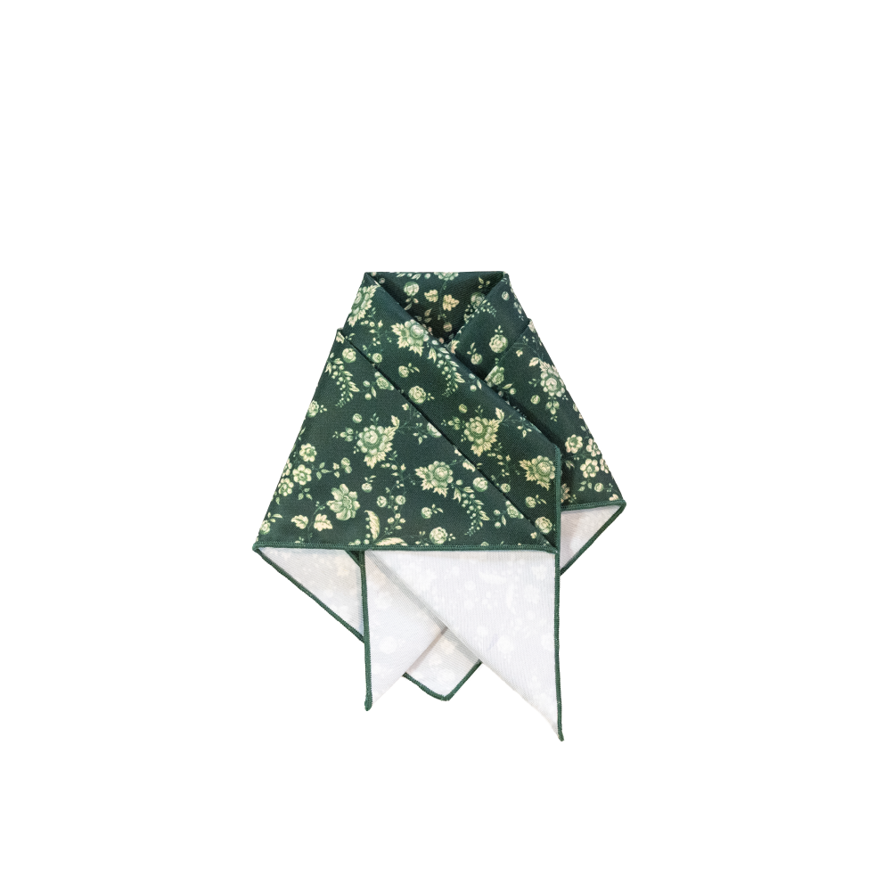 A folded pocket square with a dark green floral print on the exterior.