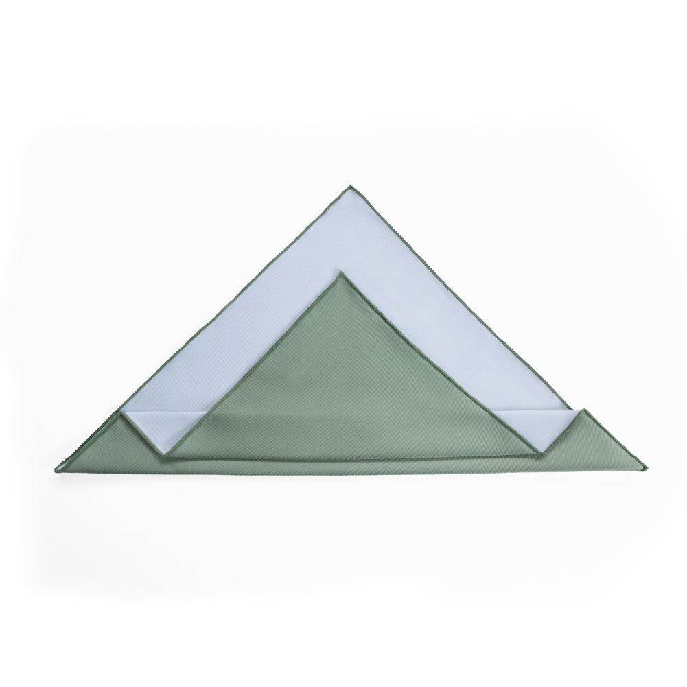 A folded pocket square with a sage green outer layer and a white inner layer.