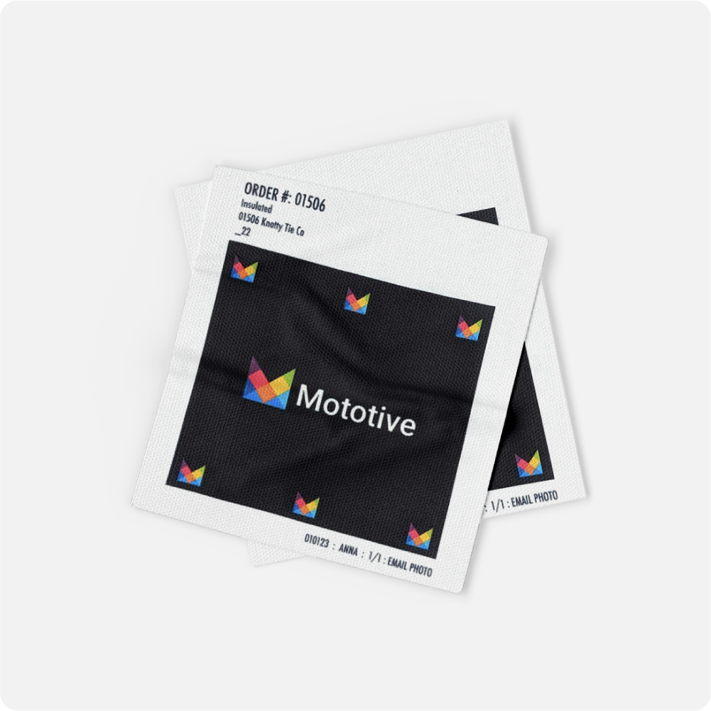 Two black fabric samples with colorful 'Mototive' logo on a white background