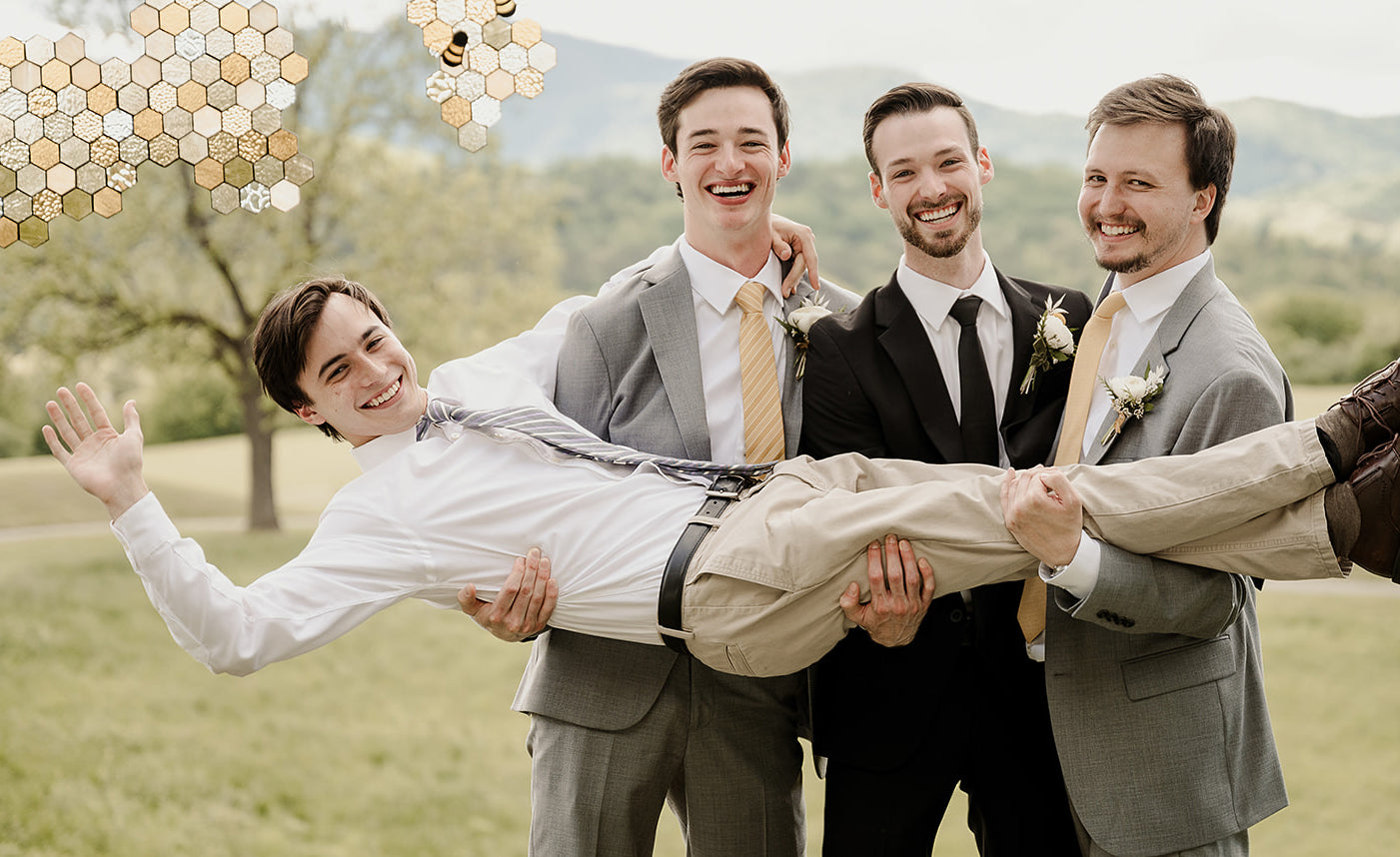 Three young men holding up another young man who is waving and all of them are wearing ties