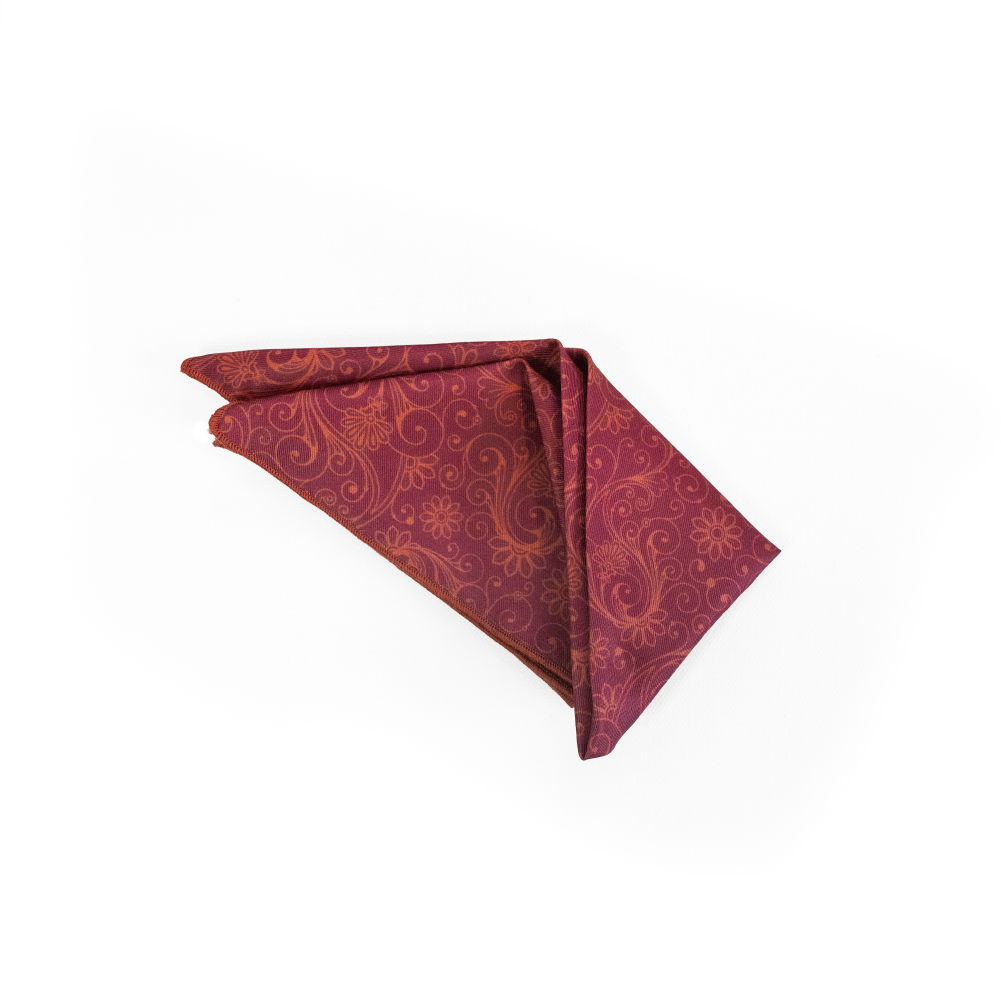 A folded red pocket square with a gold damask pattern.