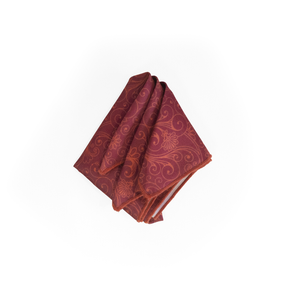 A folded red pocket square with an orange paisley pattern, displayed on a clean white background.