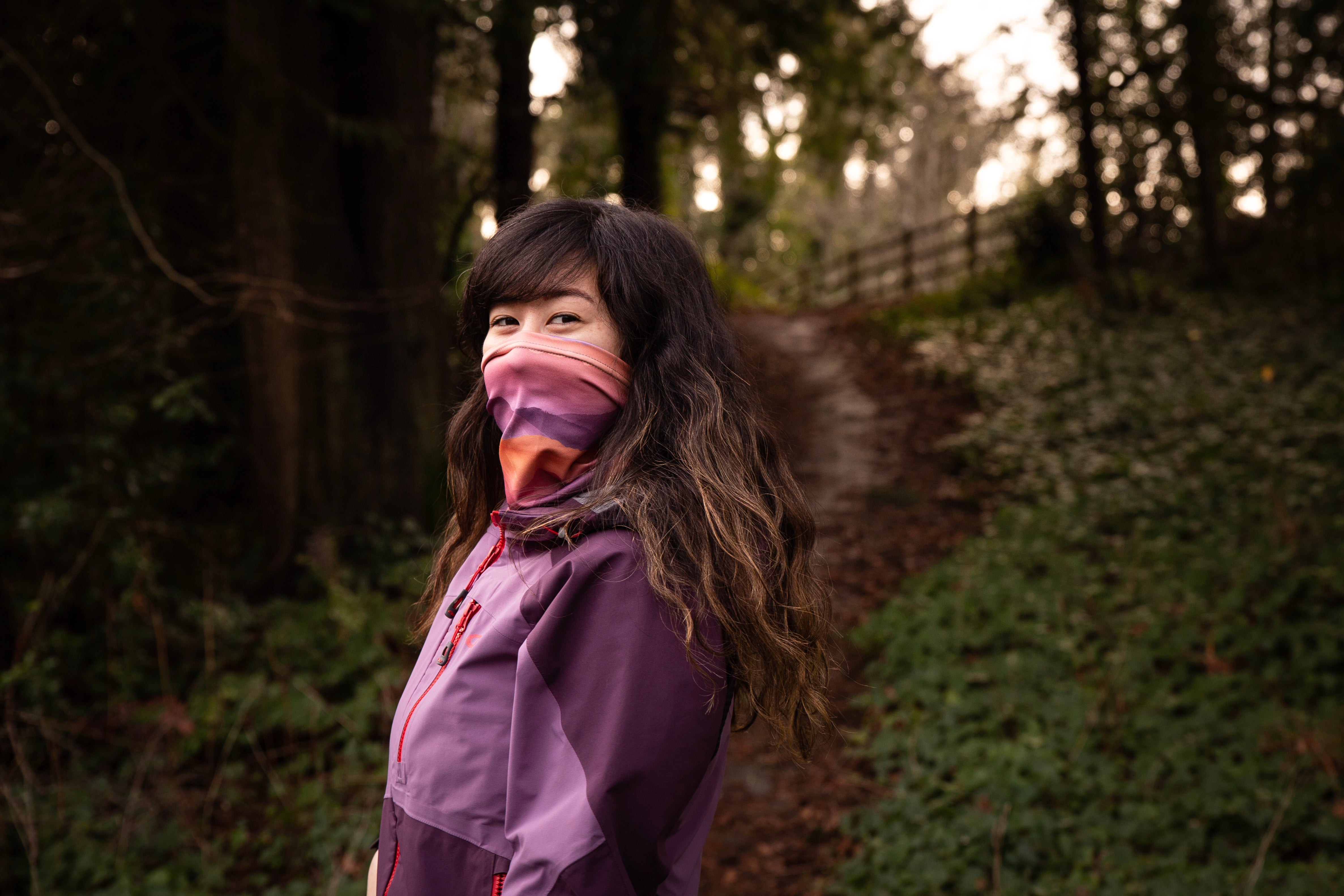 Woman wearing neck gaiter on a trail hike