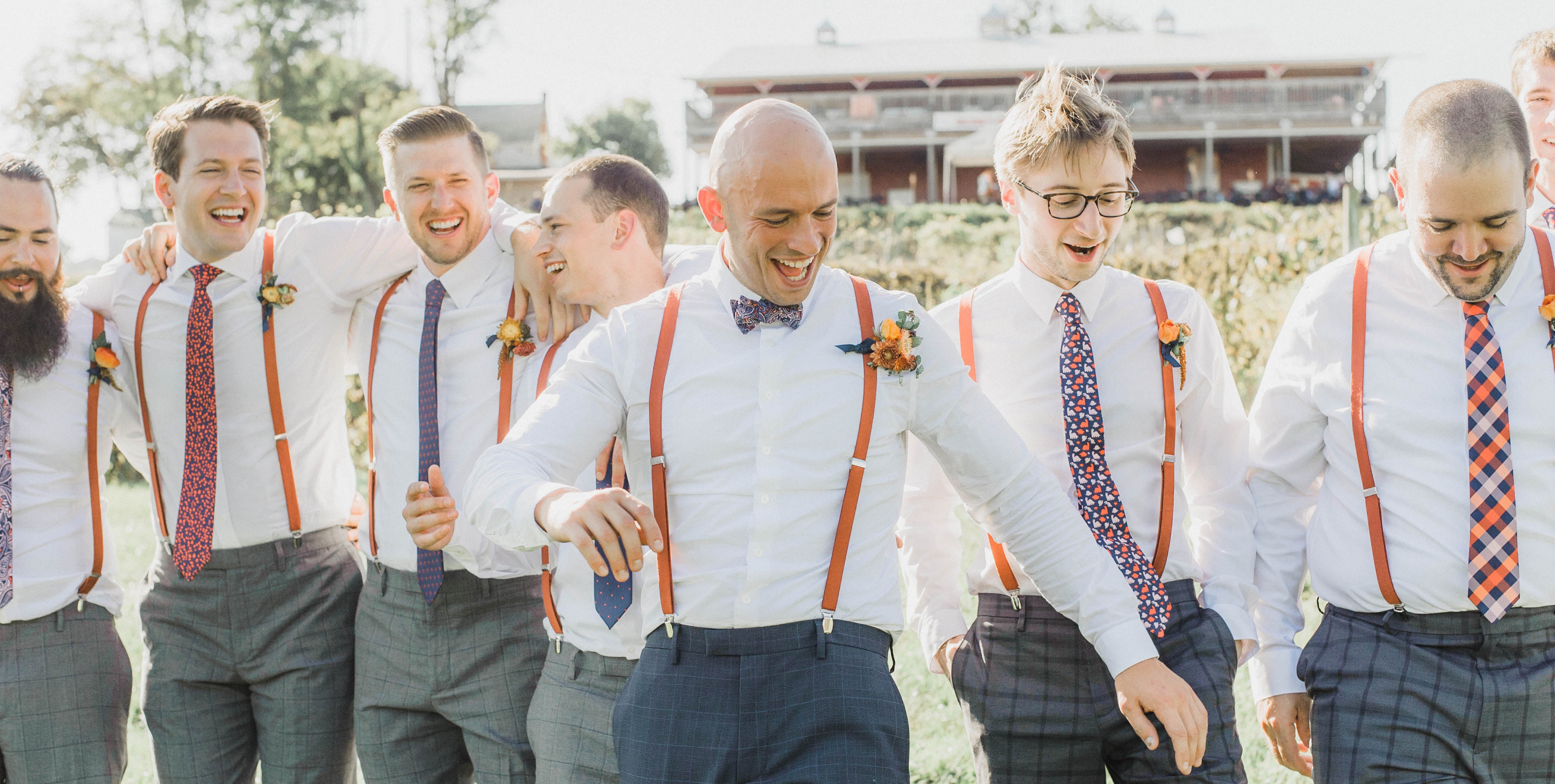 Groom and groomsmen candid photo at an outdoor wedding walking towards camera