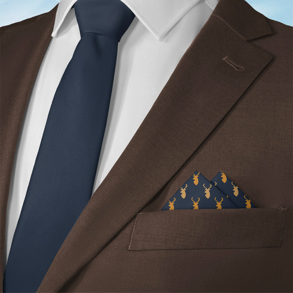 Brown suit jacket with navy tie and an animal patterned pocket square on a light blue background
