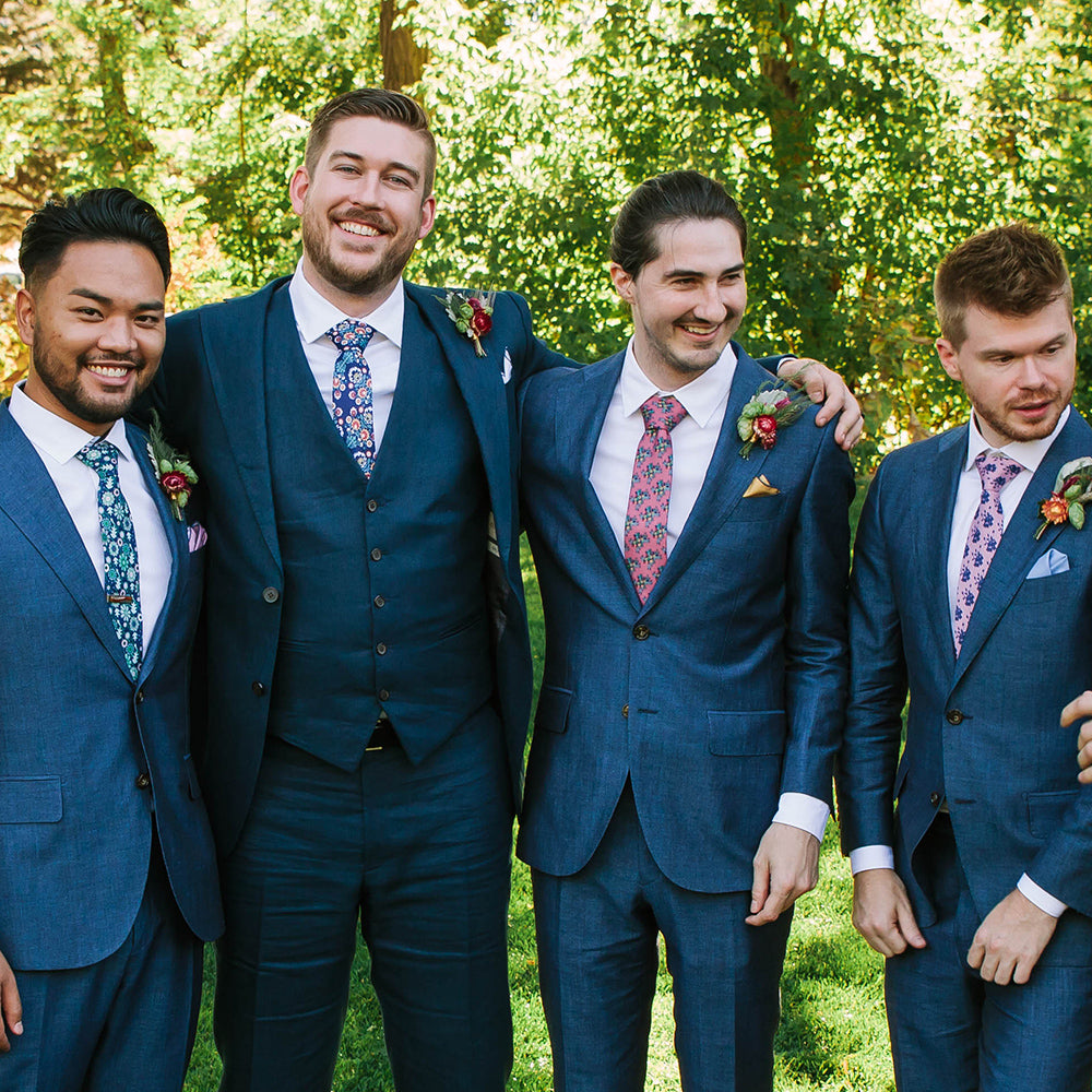 four guys wearing floral neckties with navy suits