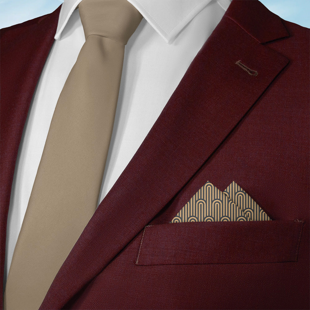Maroon suit jacket with beige tie and art deco pocket square on a light blue background