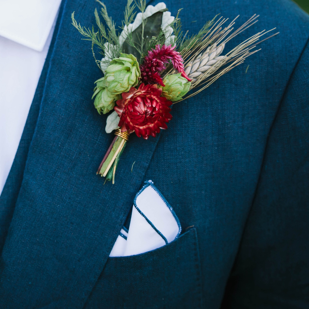 blue suit with boutonniere and white pocket square