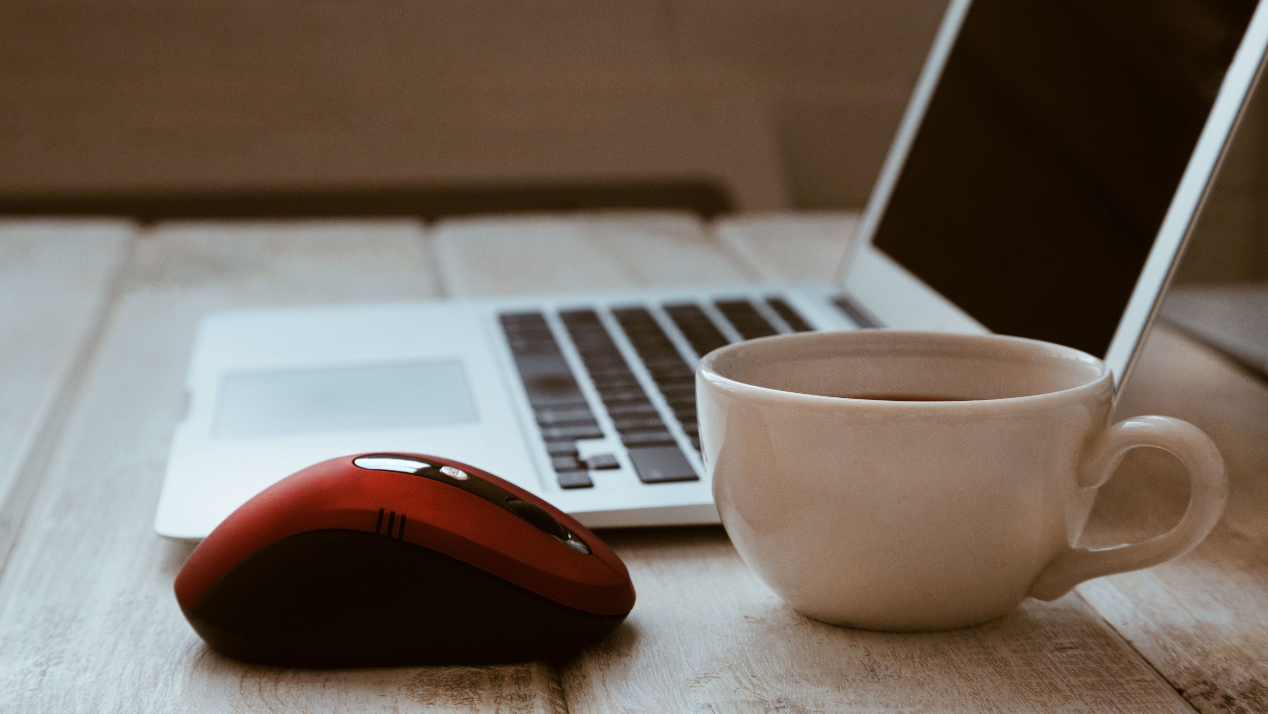 laptop on desk with coffee cup and mouse