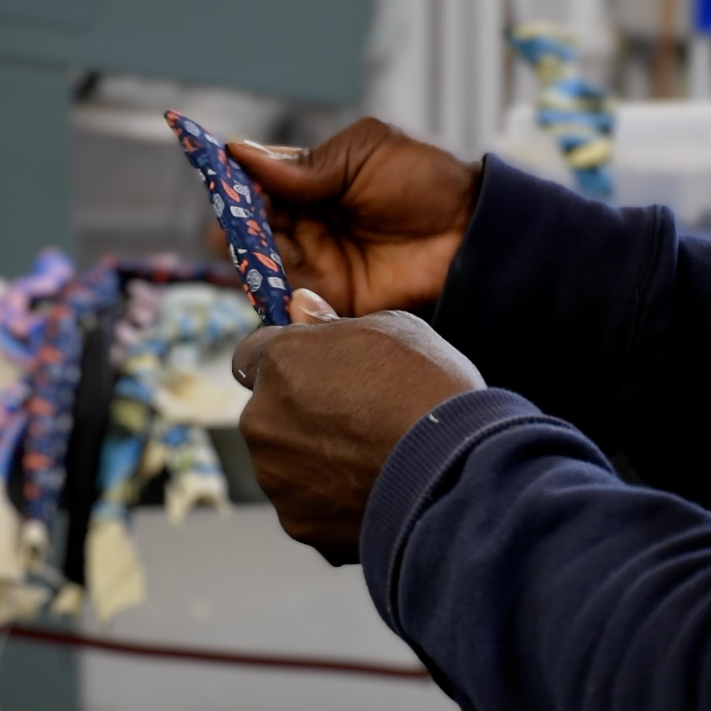 Person holding a colorful bow tie with a blurred background