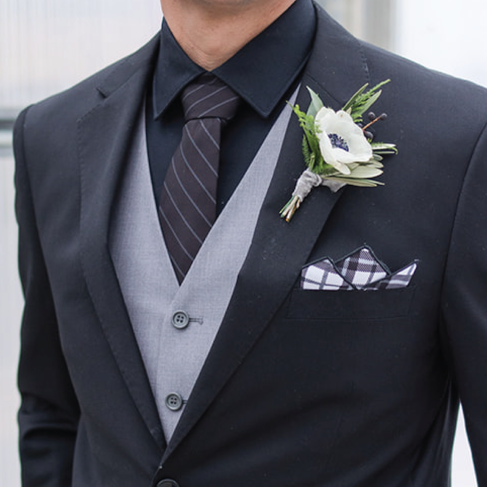 man wearing a suit with a tie, pocket square and boutonniere.