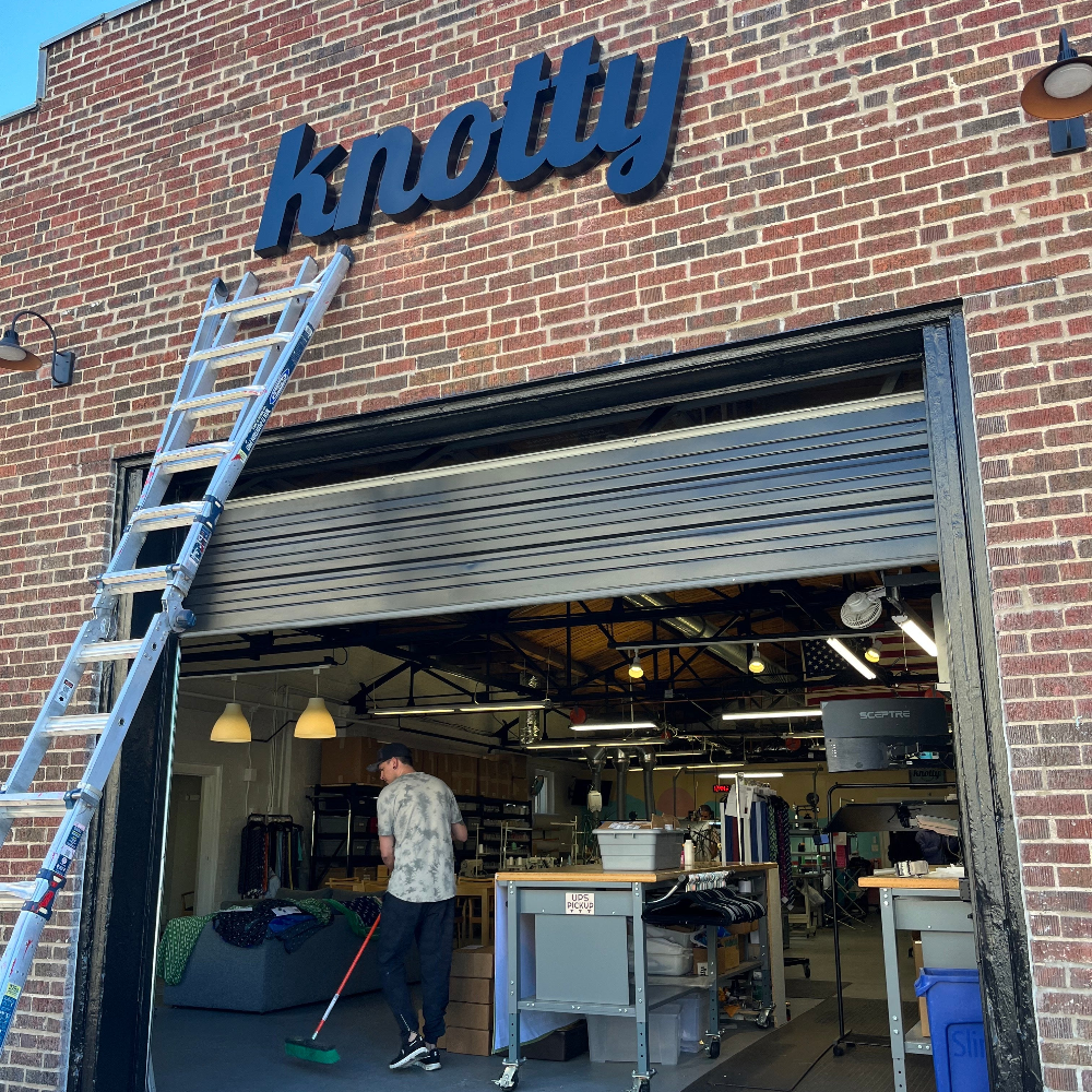 Person working inside a building with 'knotty' branding on the exterior.