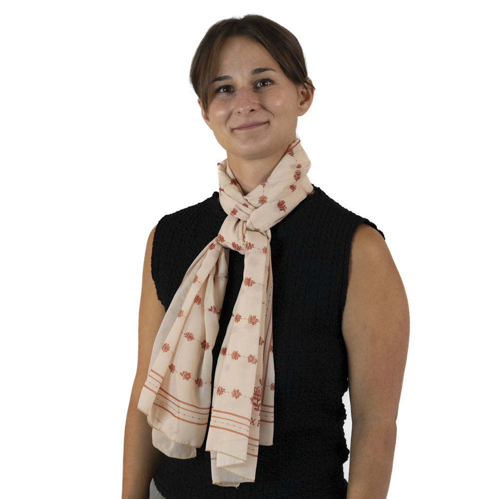 A woman wearing a cream rectangle scarf, styled around her neck in a fitted twist style
