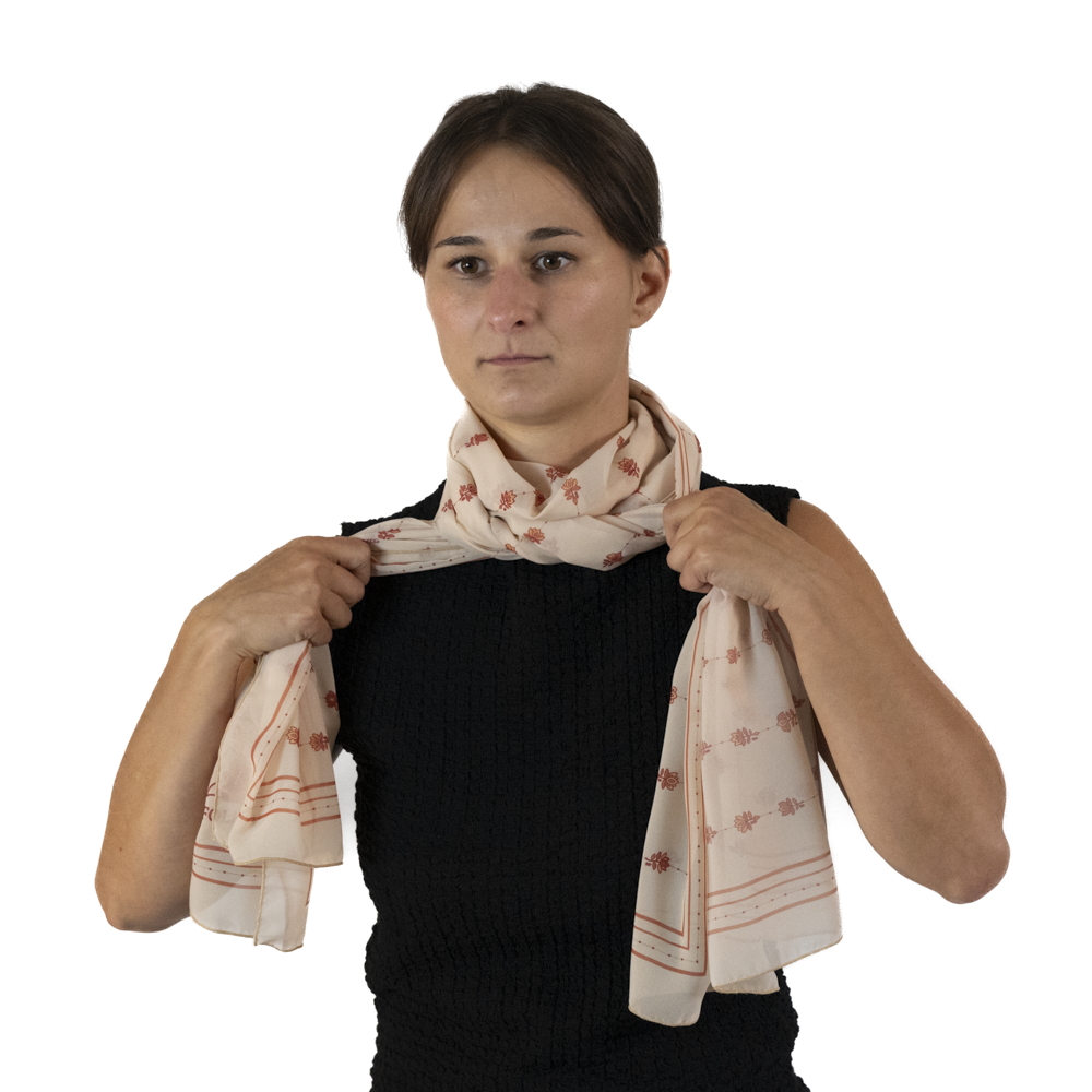 A woman tying a knot using the two ends of the rectangle scarf around her neck