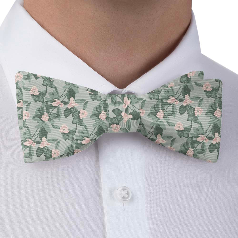 Floral patterned wedding bow tie worn by a person in a white shirt.