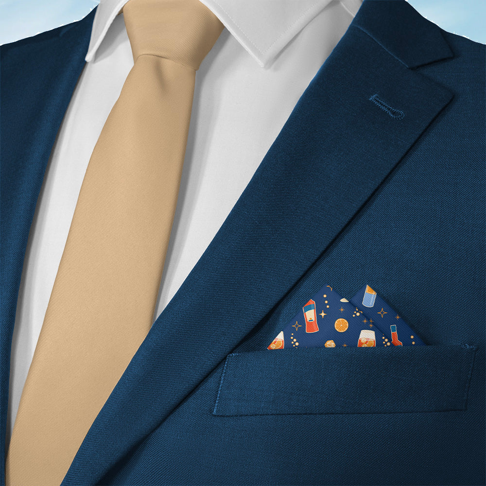 Blue suit jacket with beige tie and Aperol Spritz blue pocket square on a light blue background