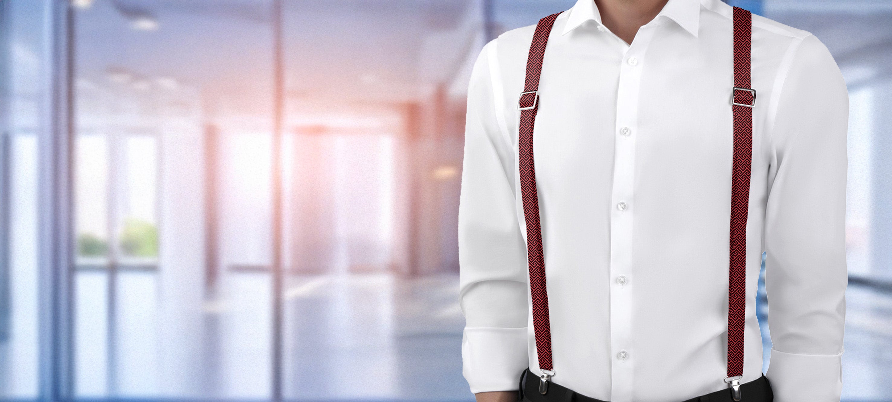 Person wearing a white shirt and red geometric suspenders in an office setting